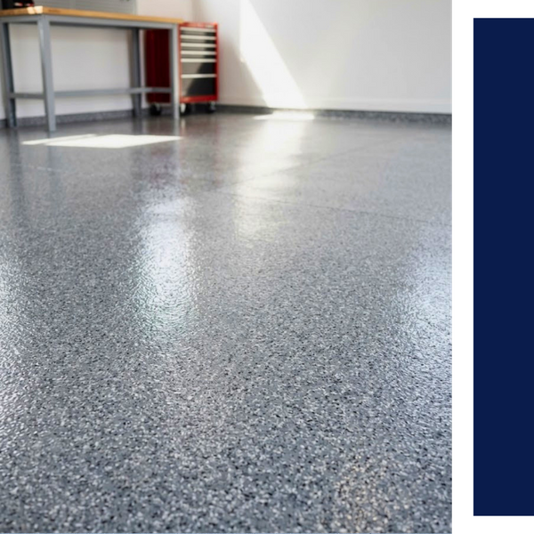 A close-up view of a glossy, light grey epoxy floor with dark grey and white flakes inside a bright garage.