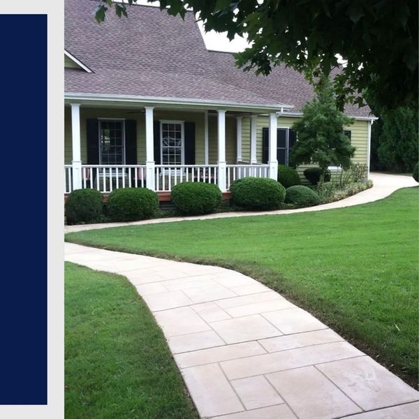 Decorative concrete walkway with a modern geometric tile pattern leading to a residential front porch.