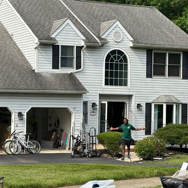 Mover standing in front of a house in Progress, PA with arms open. Mover standing in front of a house in Progress, PA with arms open.