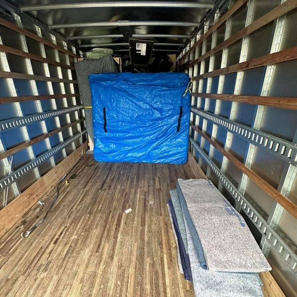 Interior of a moving truck with protective pads and a wrapped item. Interior of a moving truck with protective pads and a wrapped item.