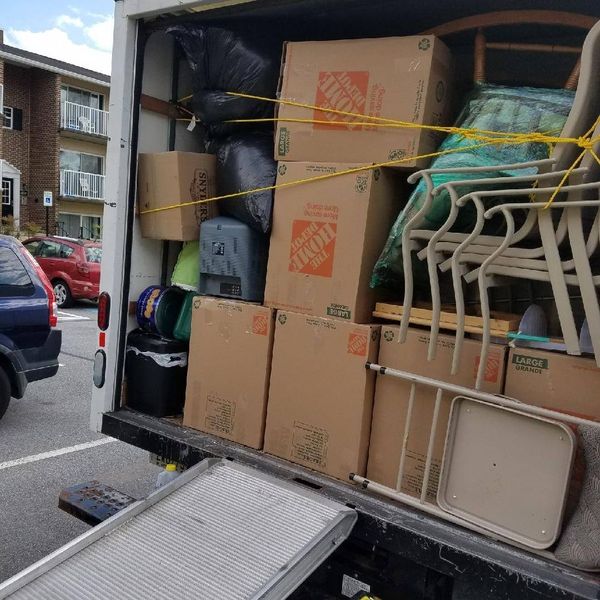 Back of a moving truck loaded with boxes and patio furniture. Back of a moving truck loaded with boxes and patio furniture.