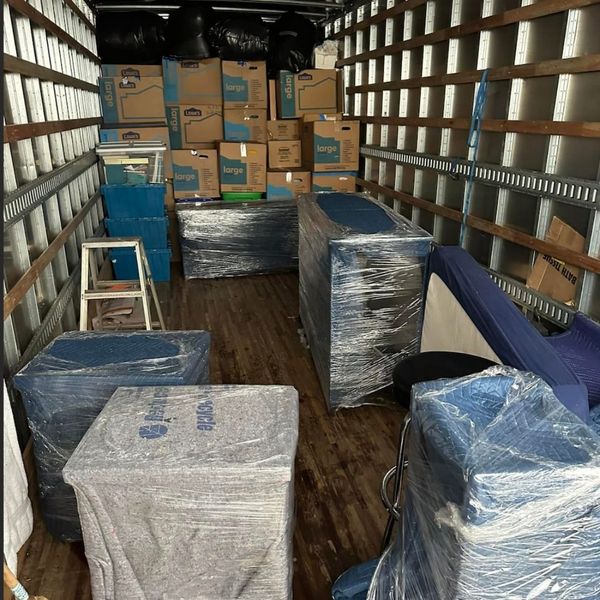 Packed boxes and wrapped items in a moving truck.