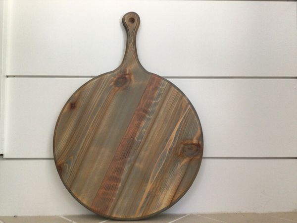 Round handcrafted charcuterie board with a handle, ready to be customized.