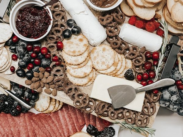 A charcuterie board with chocolate dipped pretzels and berries