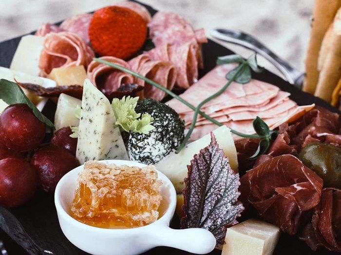 A charcuterie board with meat and honey comb