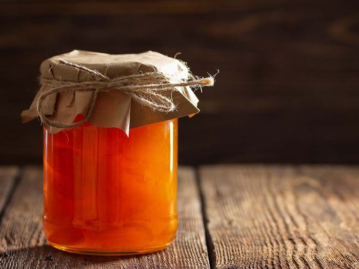 Jar with apricot jam on wooden table