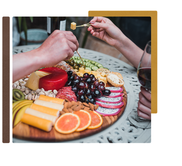 Beautiful fruits, meats, and cheese sit atop a charcuterie board from Pompo's Boards.