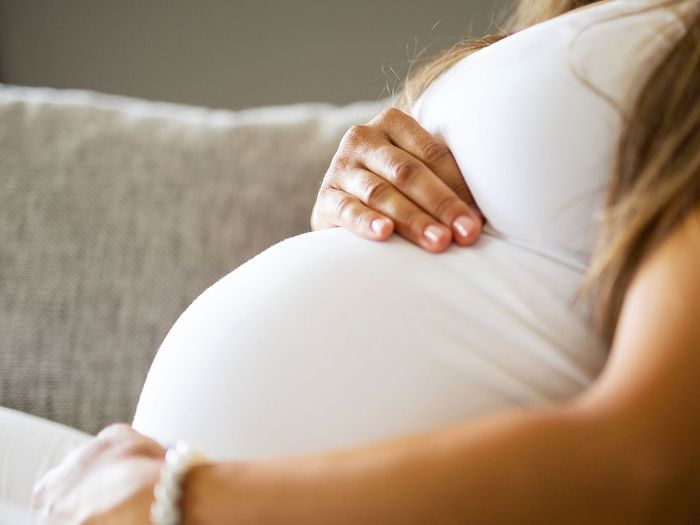 Pregnant woman holding her belly.