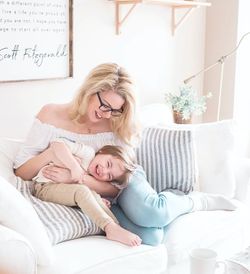 Woman and her young son smiling on the couch