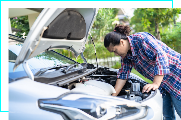 person looking under a car's hood. 