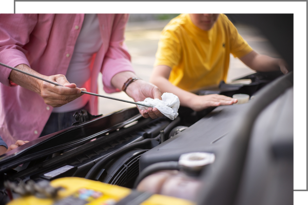 person checking oil on a car.