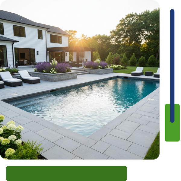 Modern, clean-lined backyard with a rectangular swimming pool, light gray stone patio, and raised planting beds with white and purple flowers.