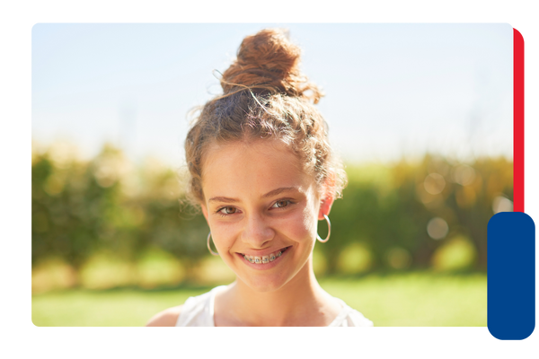 An adolescent girl with braces smiling at the camera