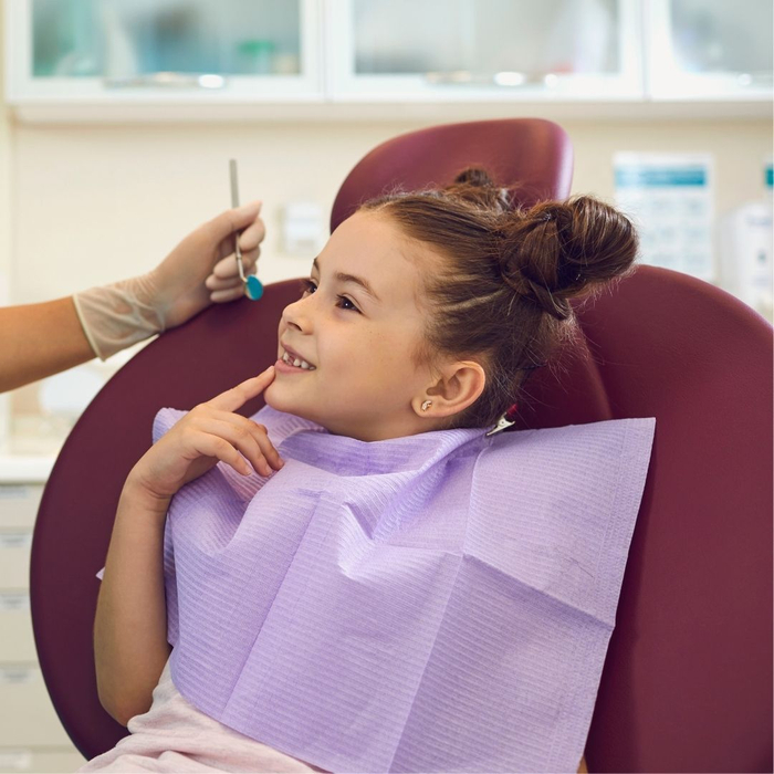 curious child in dentist chair smiling