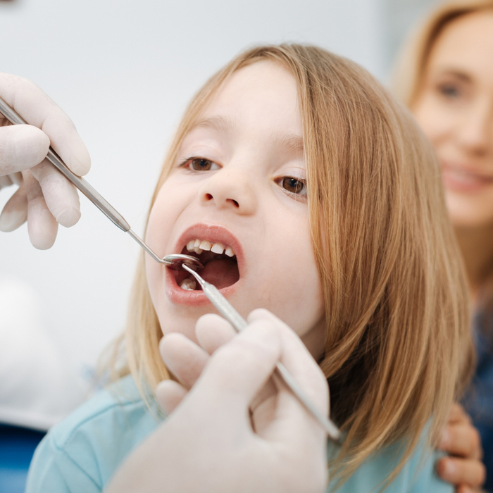 Dentist gently examining a child's teeth