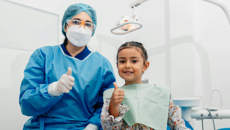 dentist and child giving thumbs up