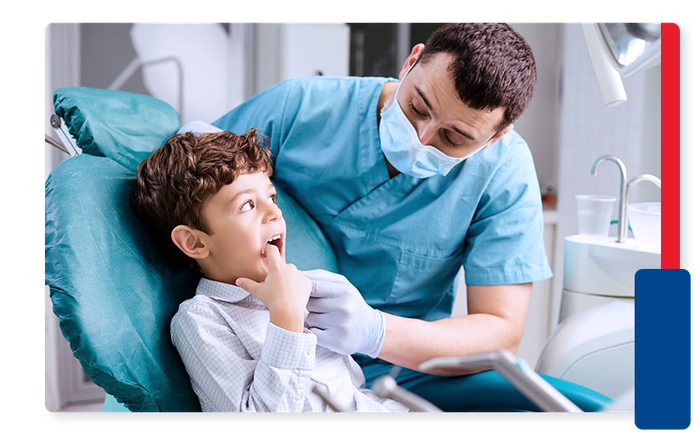 Boy pointing out tooth in his mouth to dentist