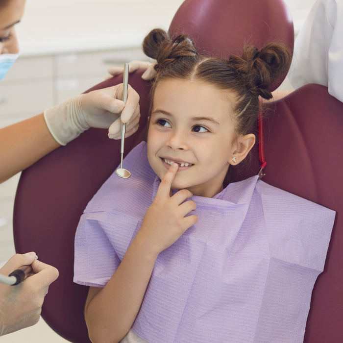 Young girl talking with dentist