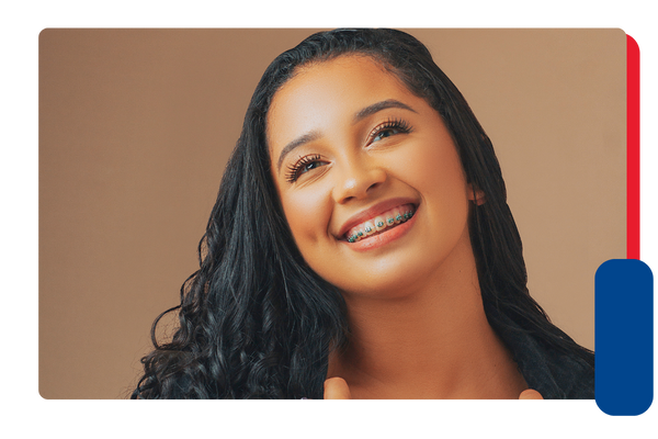 An adolescent girl with braces smiles at the camera