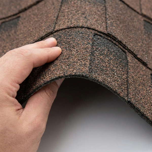 a hand bending a flexible Class 4 impact-resistant shingle