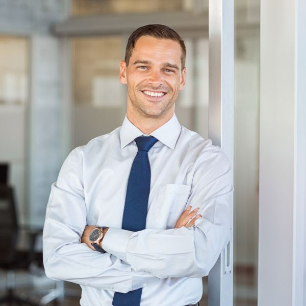 A man with his arms crossed and smiling