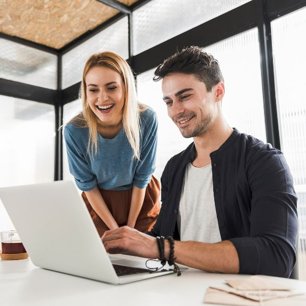 Two co workers looking at something on a laptop