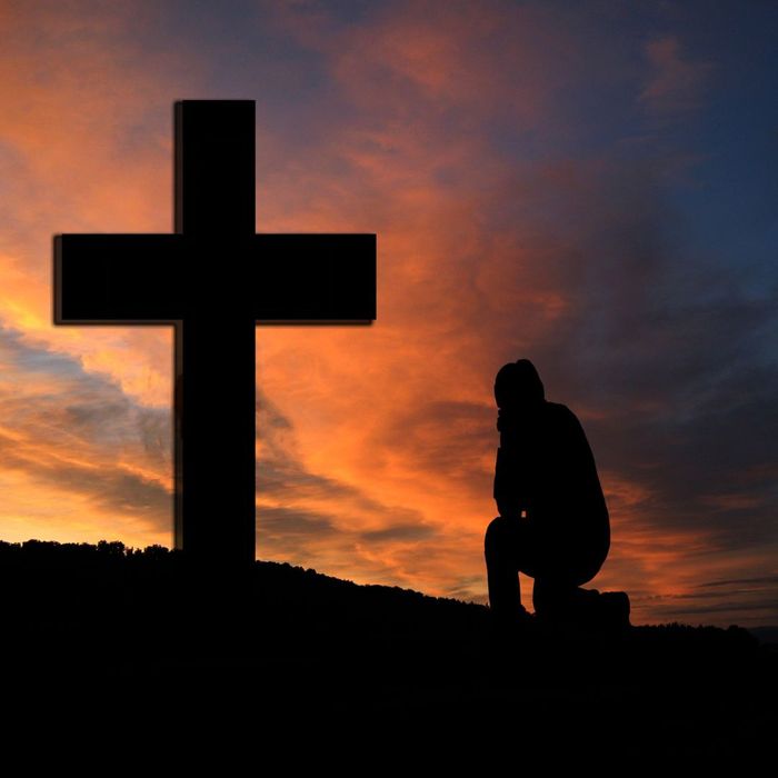 person kneeling at a cross