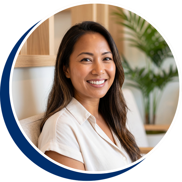 A welcoming female dentist in Pearl City, Hawaii, smiling and holding an insurance information booklet, representing Oahu Dental Care.