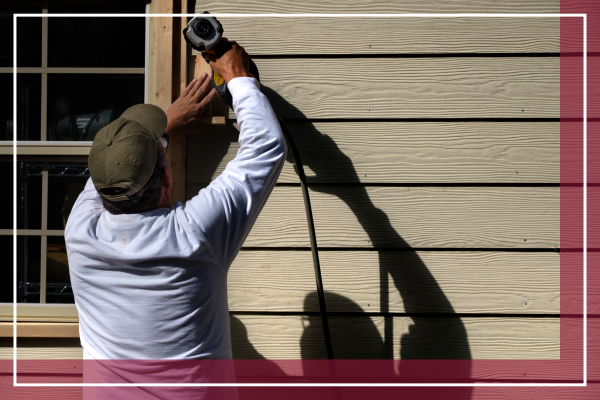 contractor installing siding on a home. 