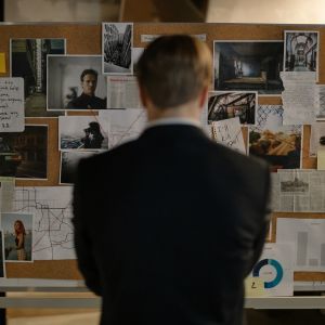 detective looking at evidence board