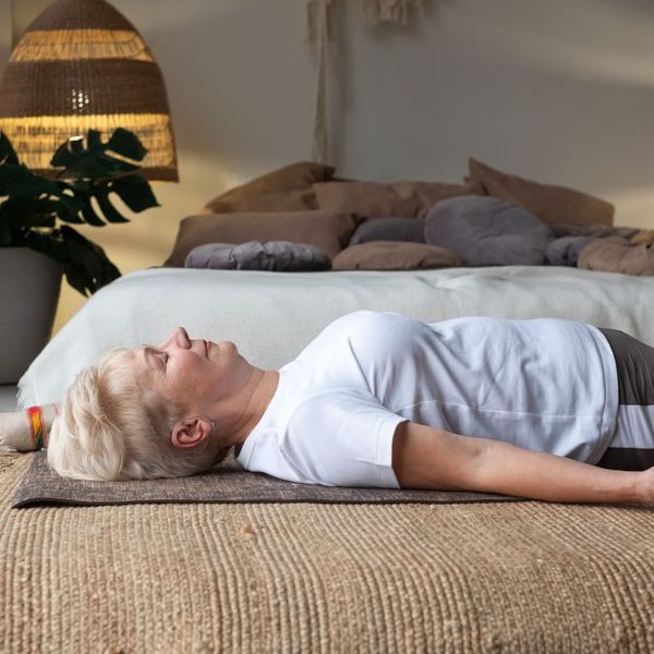 woman lying on bed doing breathing exercises