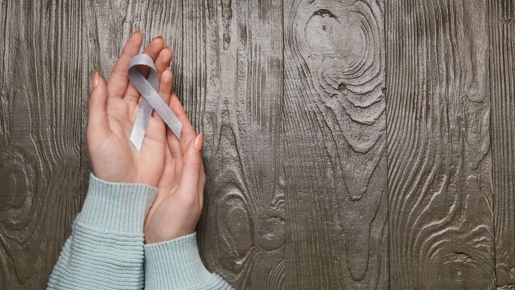 hand holding Parkinson's awareness ribbon