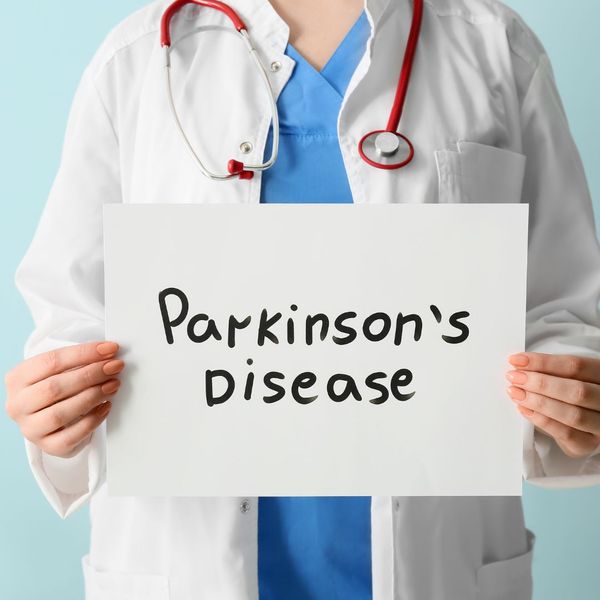 doctor holding sign that says Parkinson's disease