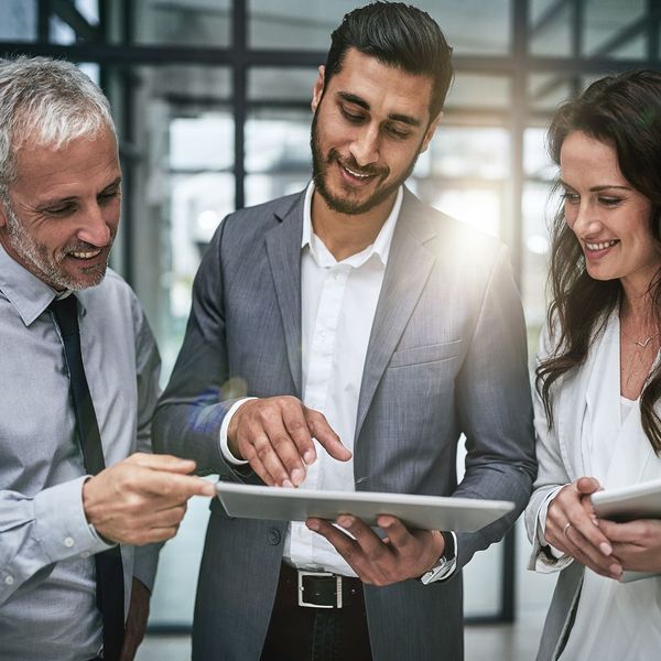 man showing co-workers something on an ipad