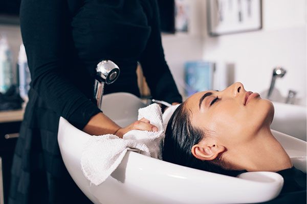 washing client's hair in basin