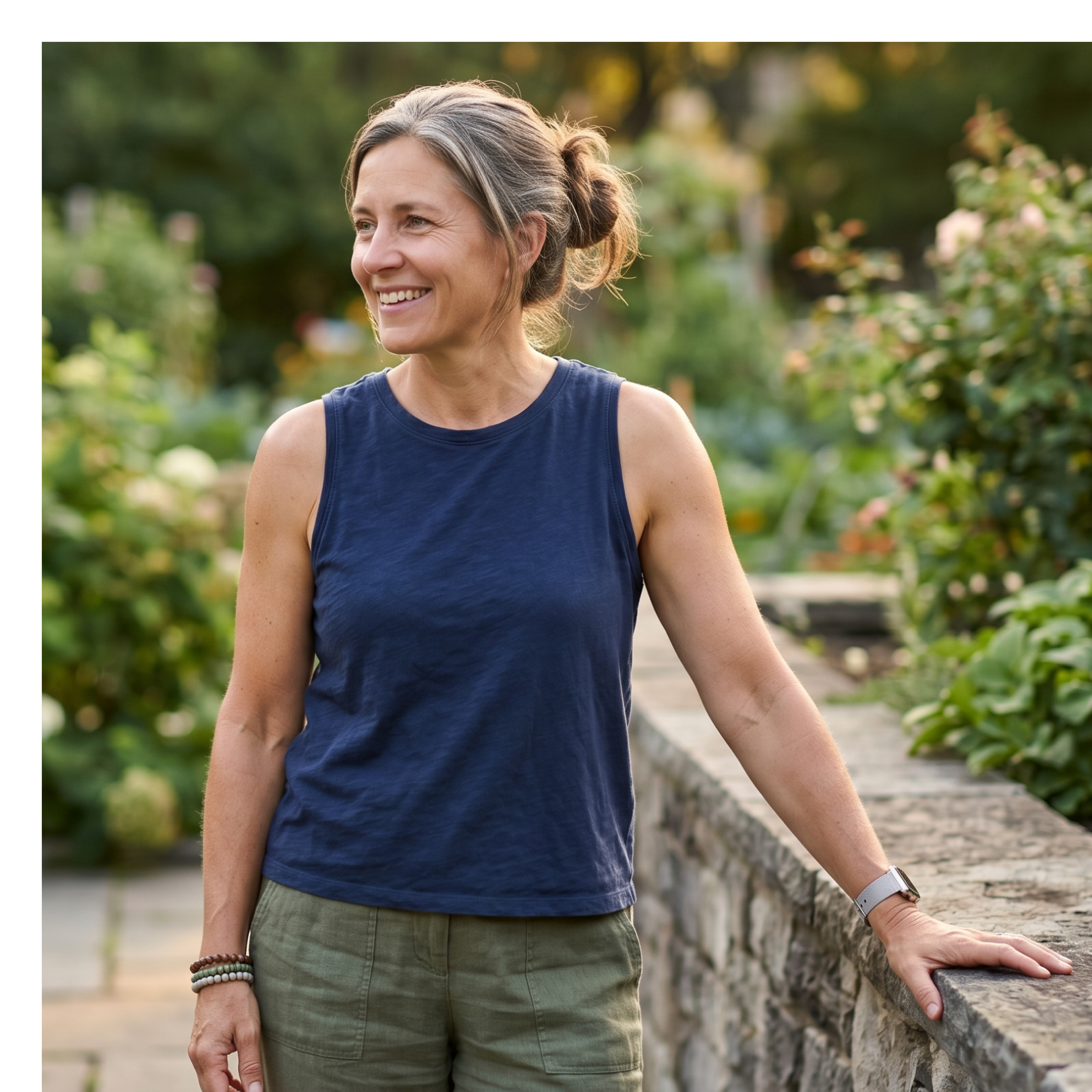 middle-aged woman leaning on a stone wall. 