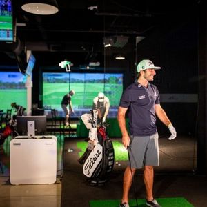 happy man wearing golf gear at X Golf