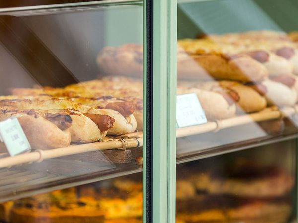 Shiny glass shop windows with hot dogs and snack foods.