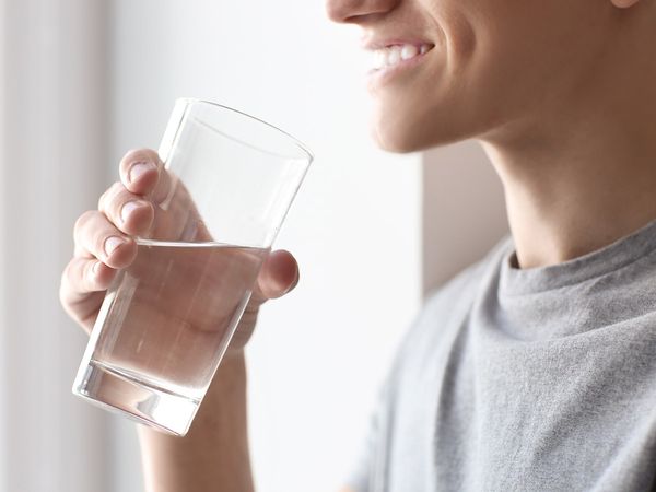 Man drinking a glass of water.