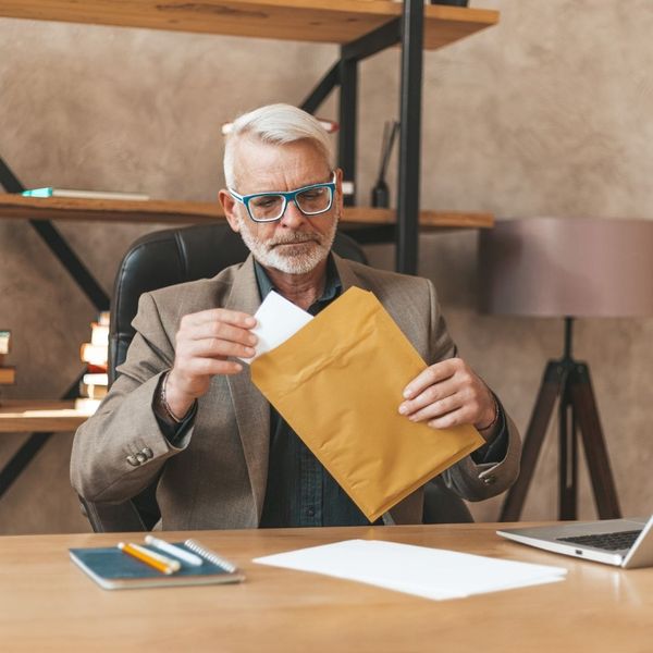 older man opening envelope with court papers