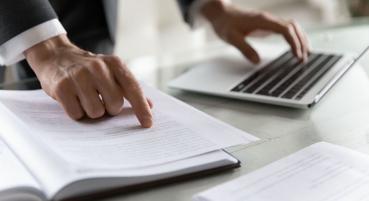 lawyer looking at court document and laptop lawyer looking at court document and laptop