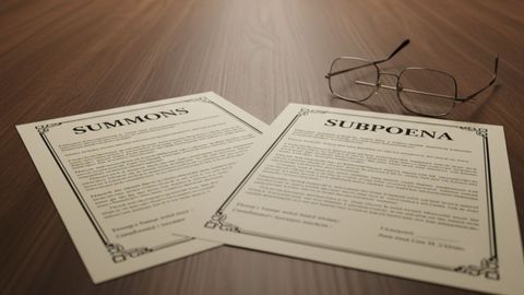 Side-by-side view of a court summons document and a subpoena document on a lawyer's desk, illustrating their distinct purposes in Illinois law.