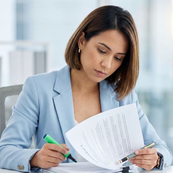 A woman marking through a contract.