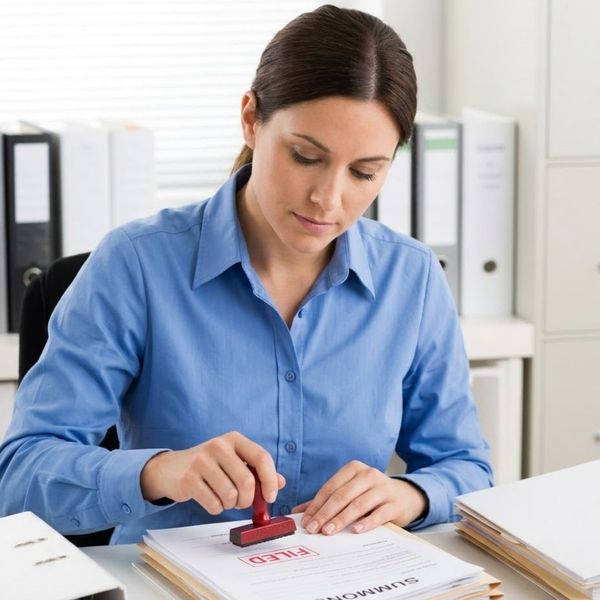 A woman stamping paperwork.