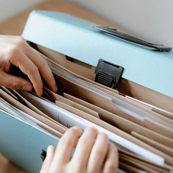 hands rifling through a document accordion file