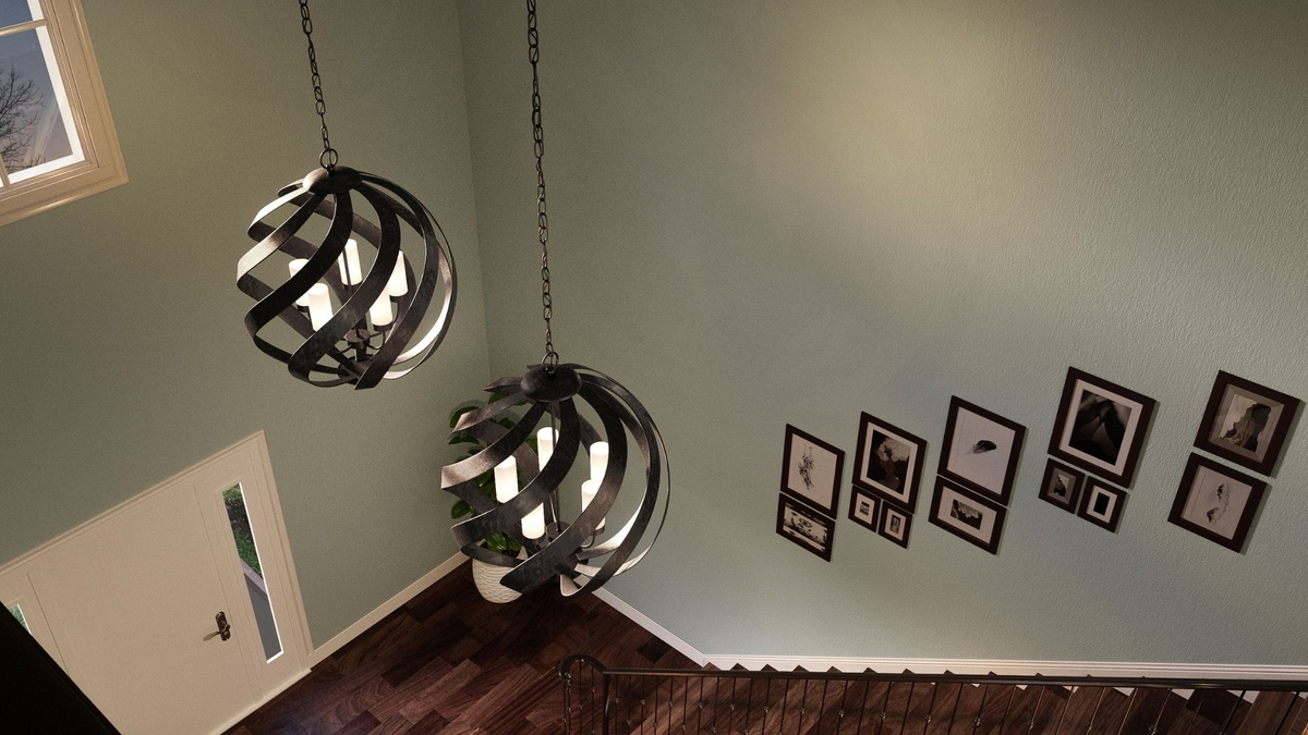 Two spherical metal chandeliers hanging in a green foyer.