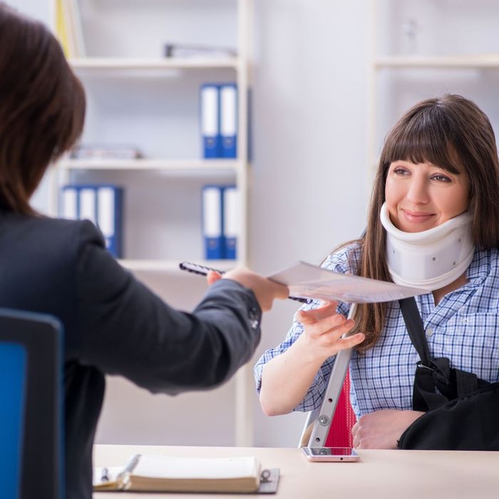 Injured woman talking to another woman about a workers compensation form.