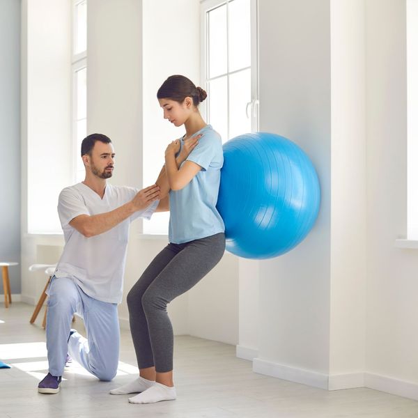 woman using medicine ball with chiropractor