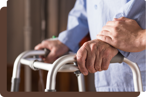 older hands resting on a walker older hands resting on a walker