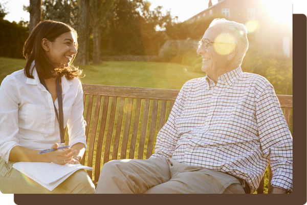 older man sitting on bench with caregiver older man sitting on bench with caregiver